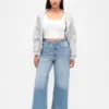 Jeans a gamba larga e caviglia, con vita alta e linea sinuosa