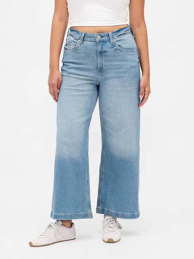 Jeans a gamba larga e caviglia, con vita alta e linea sinuosa
