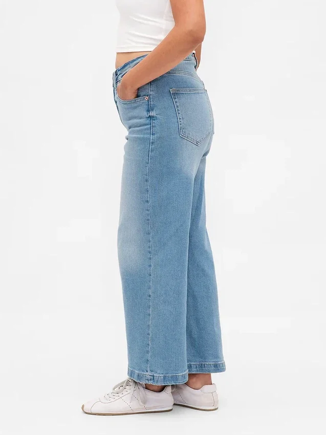 Jeans a gamba larga e caviglia, con vita alta e linea sinuosa