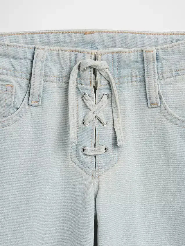 Jeans a vita bassa con chiusura allacciata e taglio svasato morbido per bambini