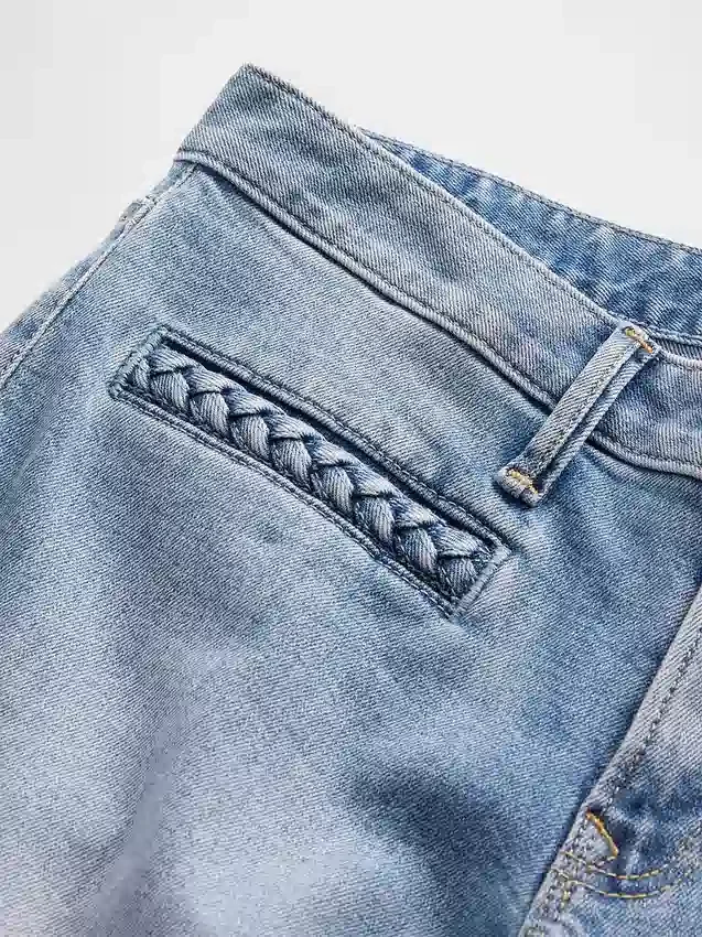 Jeans a vita bassa con tasche intrecciate, dal taglio lungo e slanciato