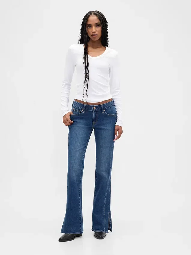 Jeans a vita bassa, lunghi e aderenti, con cuciture e orlo a spacco
