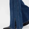 Jeans a vita bassa, lunghi e aderenti, con cuciture e orlo a spacco