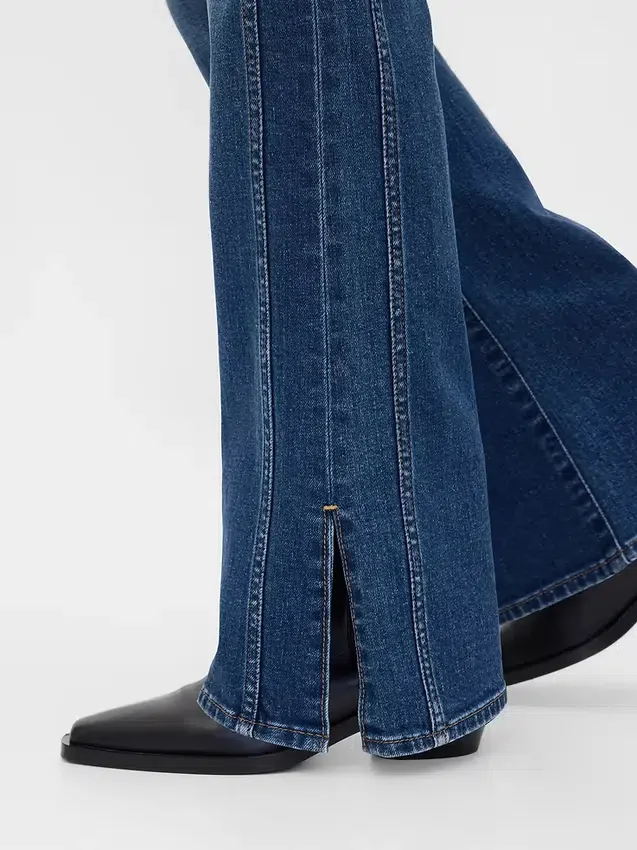 Jeans a vita bassa, lunghi e aderenti, con cuciture e orlo a spacco