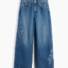 Jeans da bambino a vita bassa, gamba larga, con ricami floreali