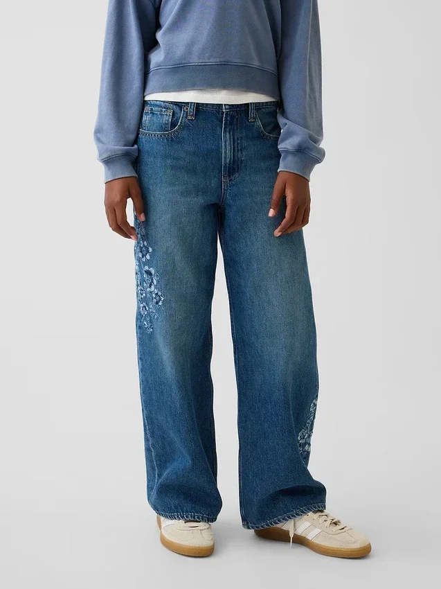 Jeans da bambino a vita bassa, gamba larga, con ricami floreali