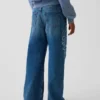 Jeans da bambino a vita bassa, gamba larga, con ricami floreali