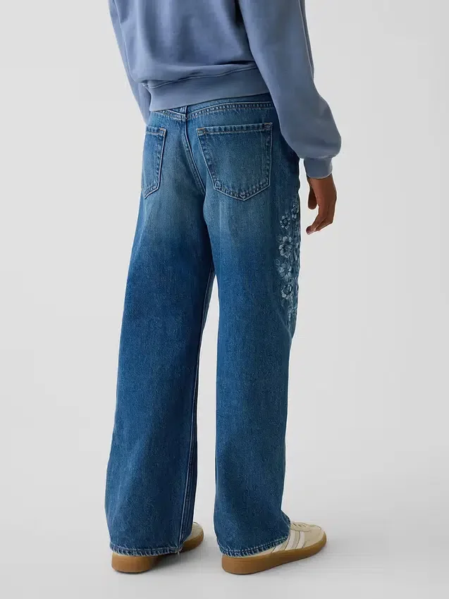 Jeans da bambino a vita bassa, gamba larga, con ricami floreali