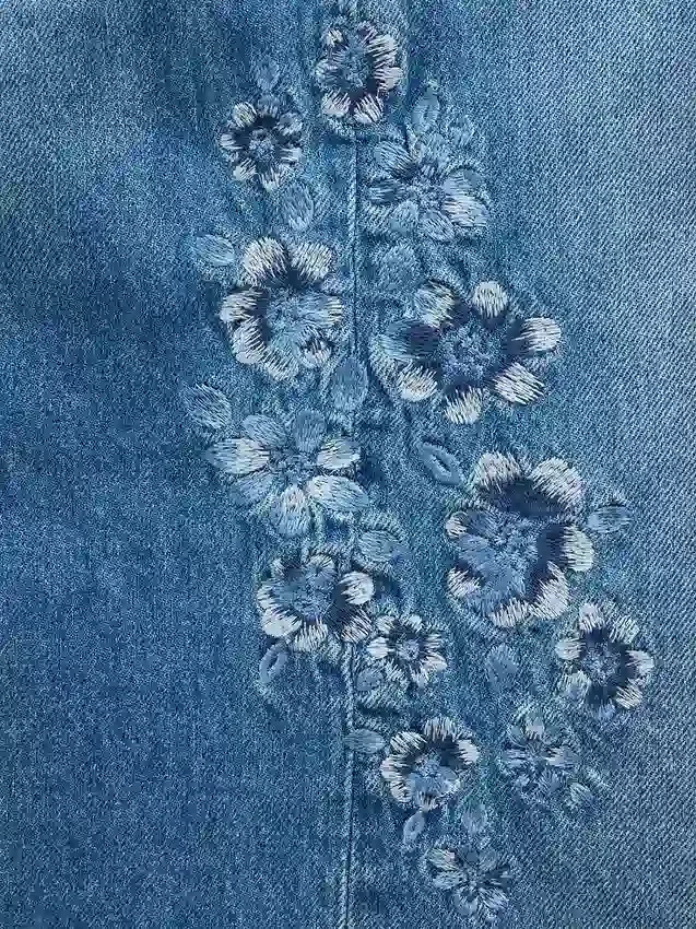 Jeans da bambino a vita bassa, gamba larga, con ricami floreali