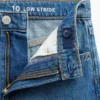 Jeans da bambino a vita bassa, gamba larga, con ricami floreali