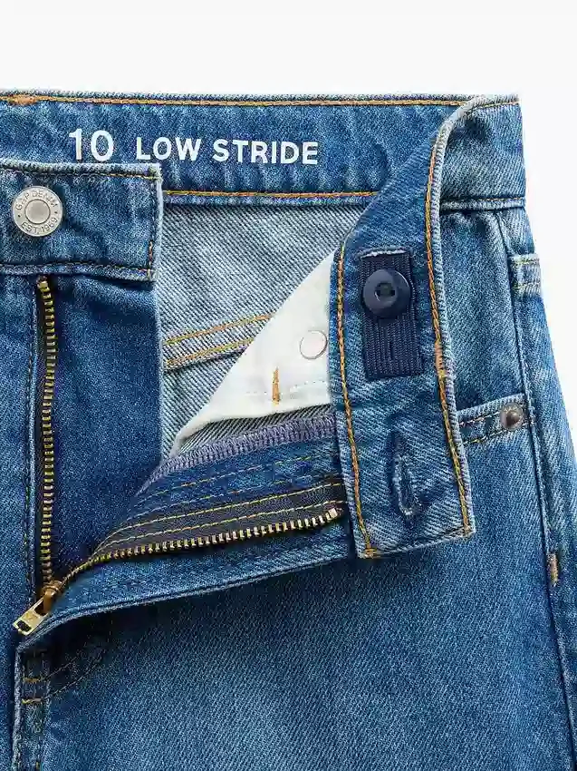 Jeans da bambino a vita bassa, gamba larga, con ricami floreali