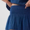 Mini gonna-pantaloncino in denim di garza di cotone con vita smockata