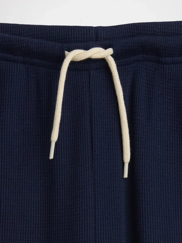 Pantaloni da bambino a gamba larga, comodi e dalla vestibilità rilassata, in maglia a nido d’ape
